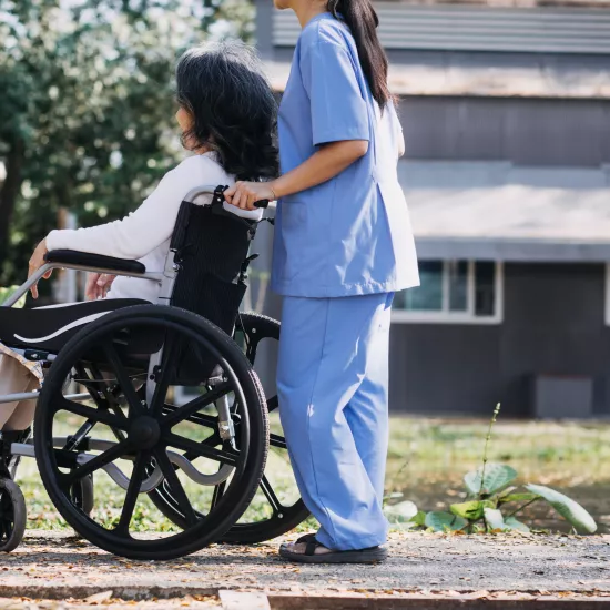 homecare worker helps a woman in a wheelchair