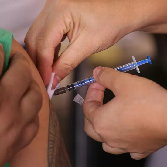 A closeup shot of a person's arm as they get a vaccine. 