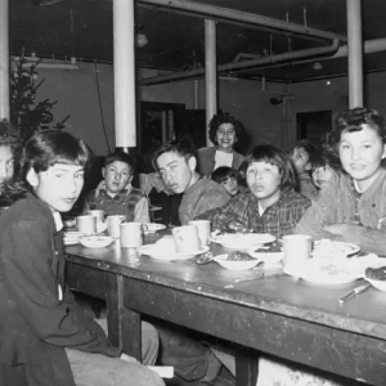 Indigenous children at a dining table in a residential school