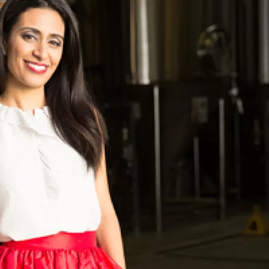 Manjit Minhas in a white shirt and red skirt