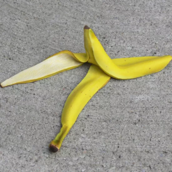 yellow banana peel on grey background
