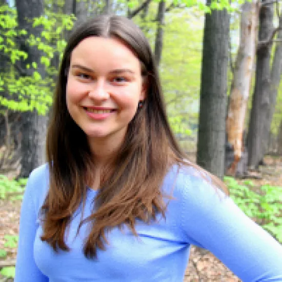 Image of Laura Krajewski standing in the woods and smiling