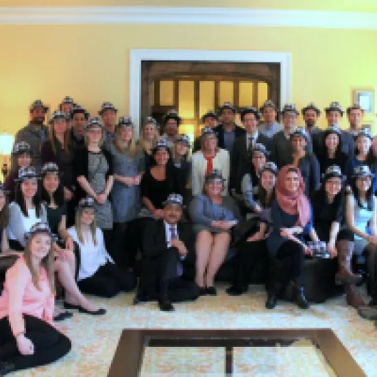 large group of people smiling and wearing plaid fedora hats