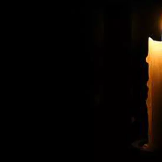 lighted candle against a dark background