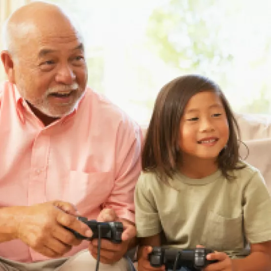 Grandfather and granddaughter play video game together