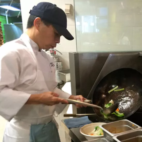 man cooking food in a wok
