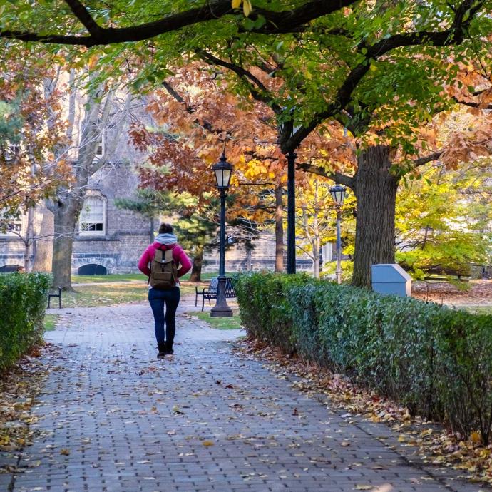Student walking on campus during fall season