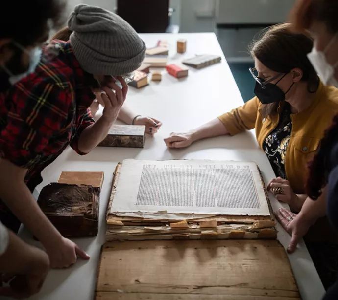 Prof. Alexandra Gillespie (right) and PhD students at the Old Books New Science lab examine an early printed codex