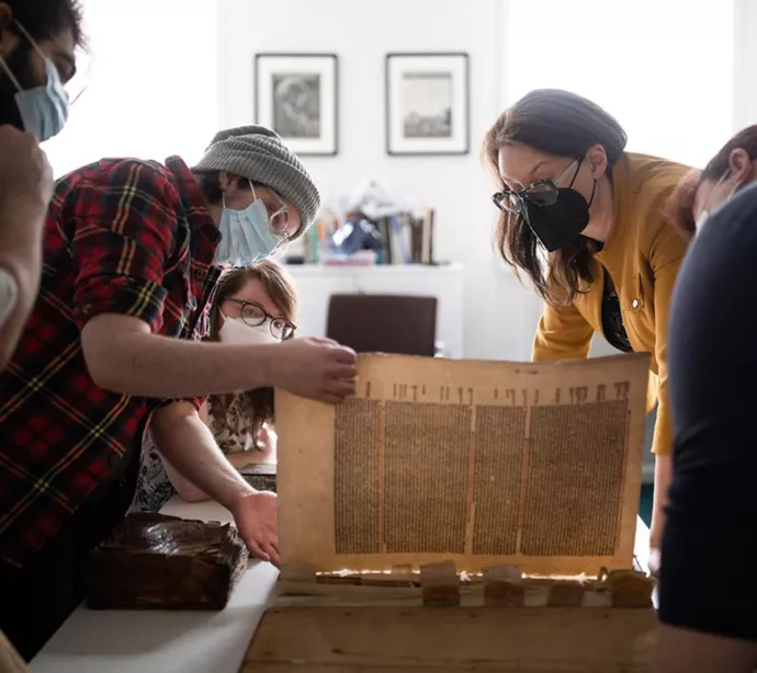 Members of the Old Books New Science lab look for the watermark in a 15th-century printed book