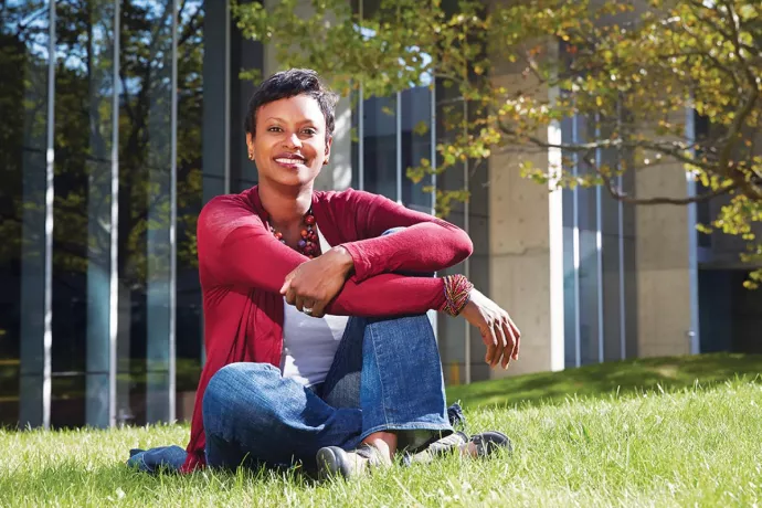 Rhonda McEwen seated on grass on the UTM campus