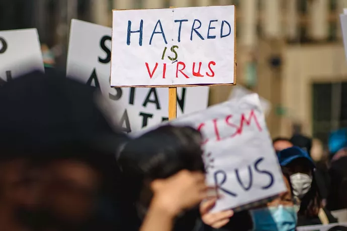 Hate crime protest sign reading "hatred is virus"