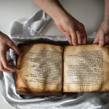 Hands holding an ancient manuscript