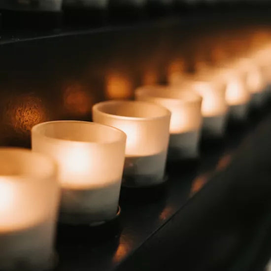 Lit candles placed side by side in a row