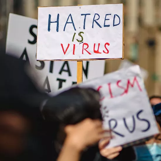 Hate crime protest sign reading "hatred is virus"