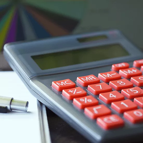Close-up image of a calculator, pen, and notebook