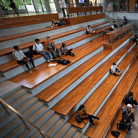 Students sit on stairs in the MN Atrium
