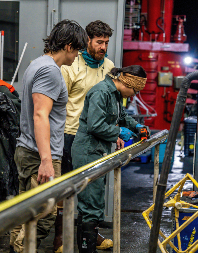 Gerard Otiniano (UTM), Drew Cole (MARSSAM coring technician) and Anna To (UQAM) measuring a long core prior to cutting it into sections.